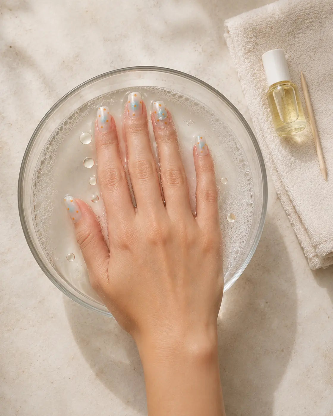 Press-on nails being removed slowly after softening the adhesive