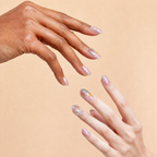 Two hands wearing Begin Again iridescent floral press-on nails on a peach background