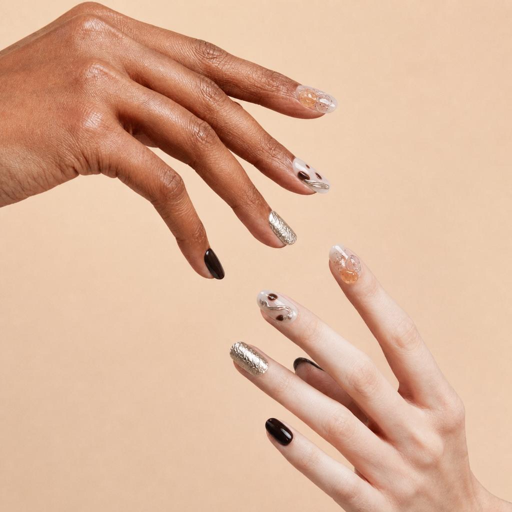 Two hands wearing First Light brown gold citrine press-on nails on a peach background