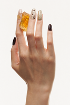 Hand wearing First Light brown and gold press-on nails with citrine and metallic foil
