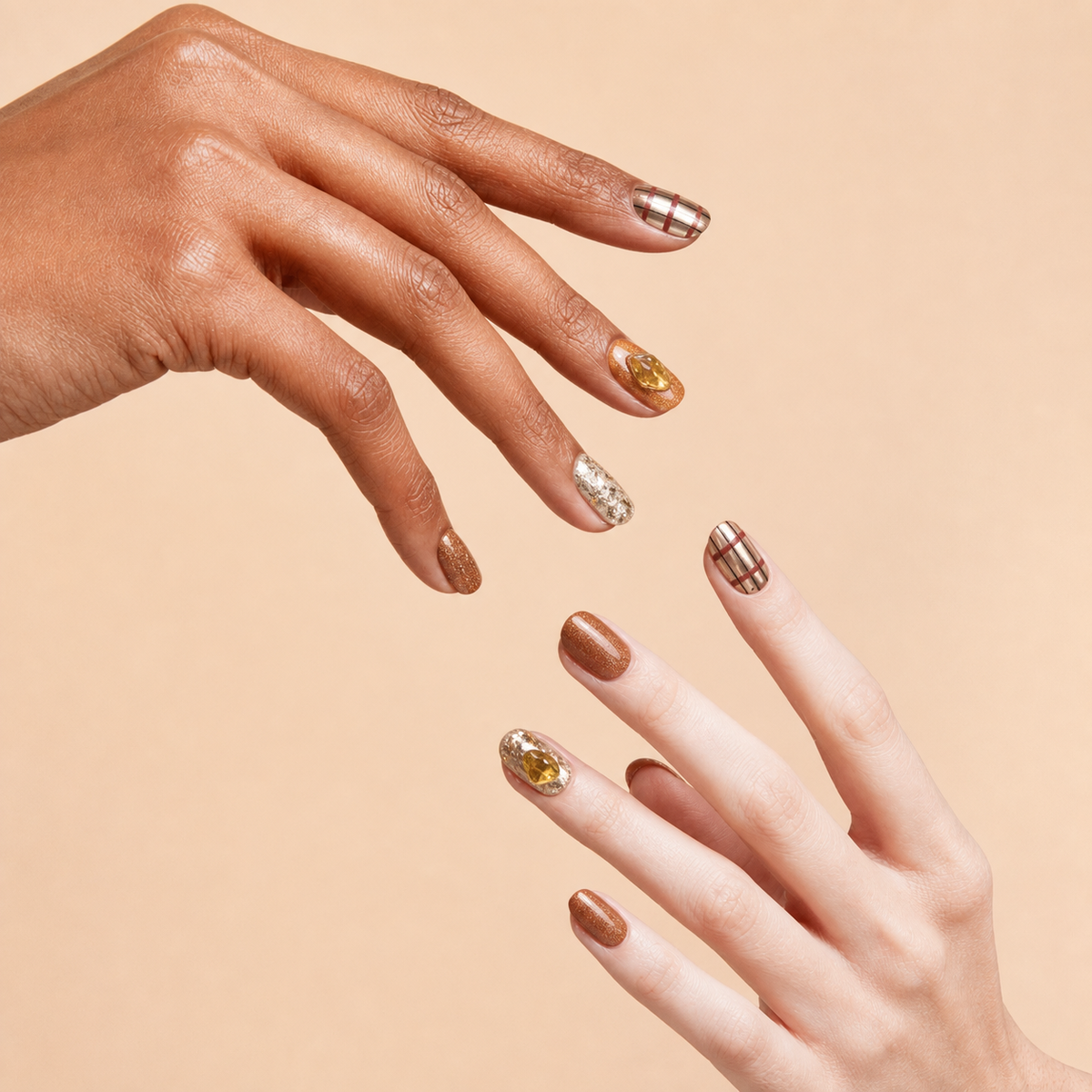 Two hands wearing Golden Hour bronze metallic citrine press-on nails on a peach background