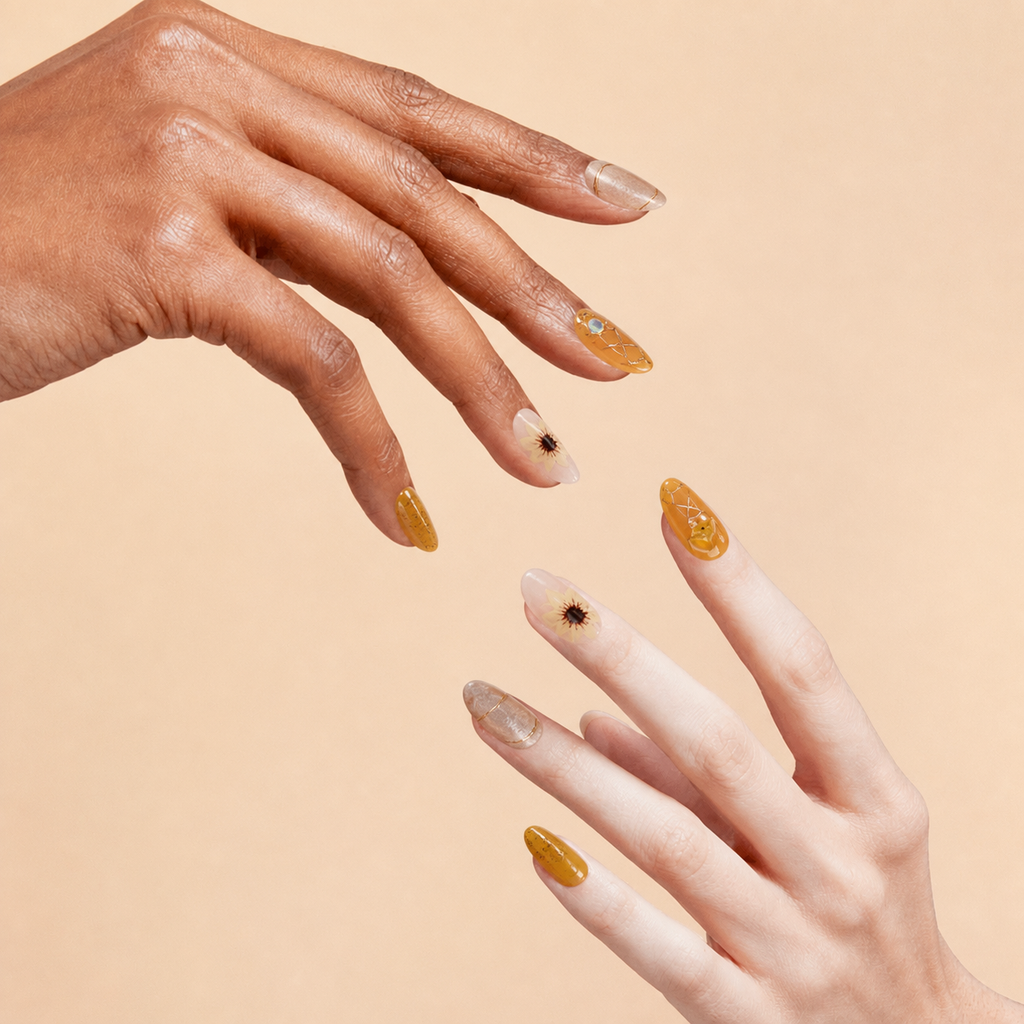 Two hands wearing Quiet Light amber floral crystal press-on nails on a peach background