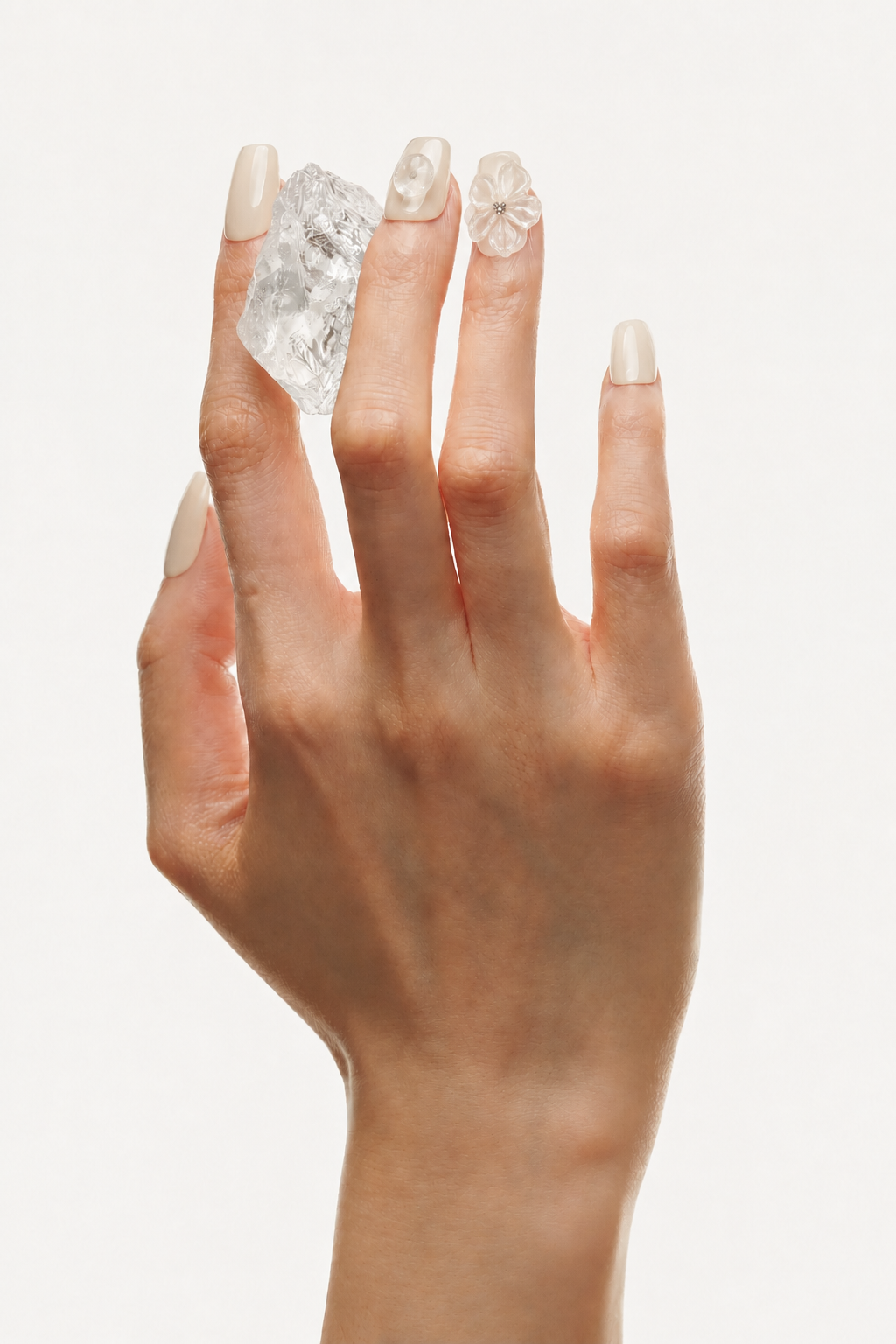 Hand wearing Untangled white 3D floral press-on nails with clear quartz accents
